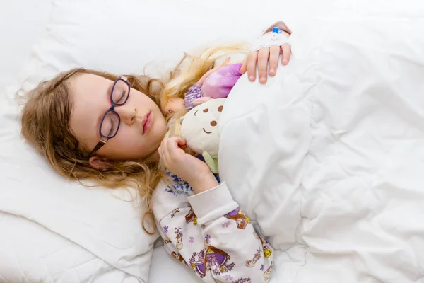 Criança pré-escolar é deitado doente em uma cama no quarto do hospital — Fotografia de Stock