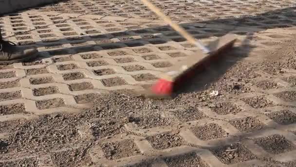 Worker Cleaning Modern Cobblestone Red Broom Worker Sweeps Dry Filth — Stock Video