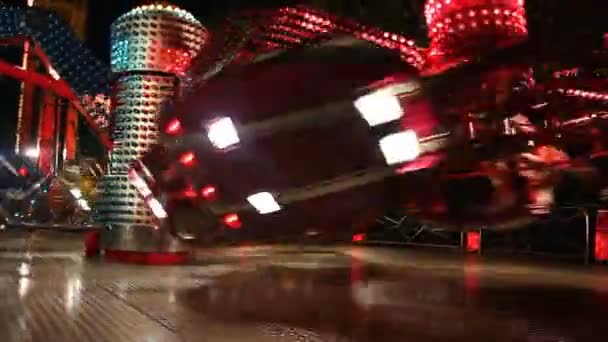 夜ルナ公園の鮮やかな照明に照らされたカラフルなカルーセルを回転 Nightfast で遊園地でカラフルな糸車 — ストック動画