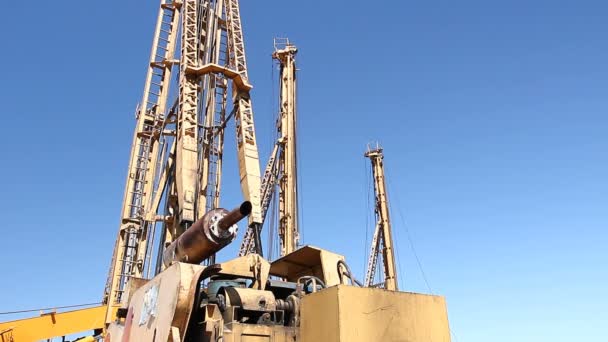 ボール盤の掘削機 Towerstowers に立っている青い空 地面にドリルの大きな機器で背が高くて — ストック動画