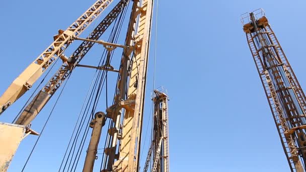Towerstowers 钻机在蓝天下高高矗立 钻入地面的大设备 — 图库视频影像