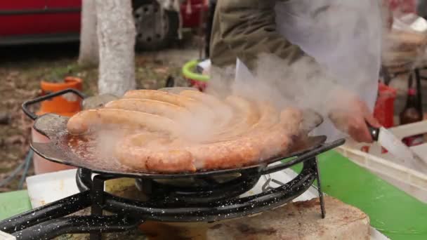 料理は自家製ソーセージとバーベキューに配置します 新鮮な生のジューシーなソーセージ つずつの山から取っているとホット バーベキュー プレートに置く — ストック動画