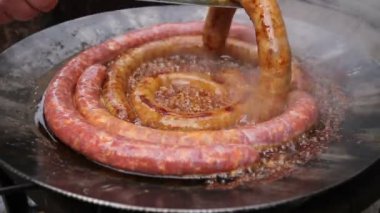 Handlehand metal maşa yardımıyla ile Barbekü plaka lezzetli sulu sosis açma kaynayan sosis bir siyah Barbekü Izgara döner. 