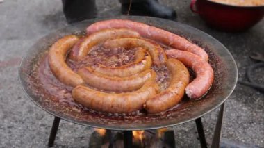 Handlehand metal maşa yardımıyla ile Barbekü plaka lezzetli sulu sosis açma kaynayan sosis bir siyah Barbekü Izgara döner. 
