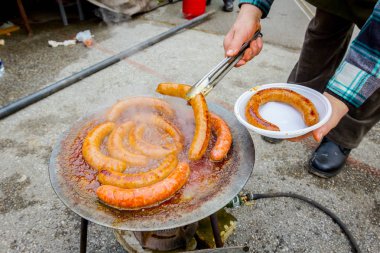 Cook lezzetli sulu sosis ızgara tabağında deler.