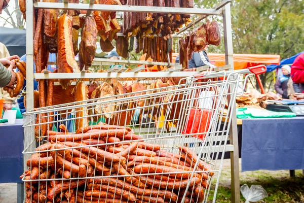 Venta de carne ahumada en puesto, carrito de mercado con salchichas — Foto de Stock