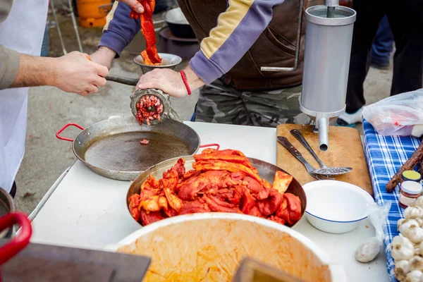 La gente macina carne per salsicce fatte a mano in cucina all'aperto — Foto Stock