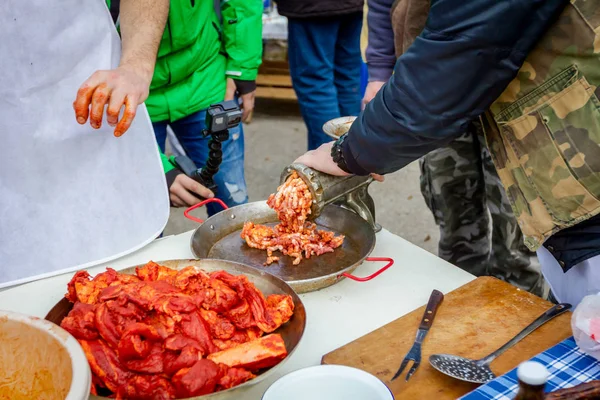 人々 は屋外の台所で手作りソーセージの肉をミンチします。 — ストック写真