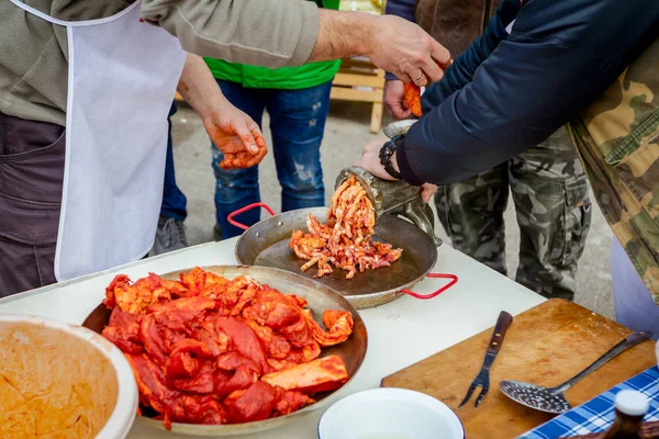 人々 は屋外の台所で手作りソーセージの肉をミンチします。 — ストック写真