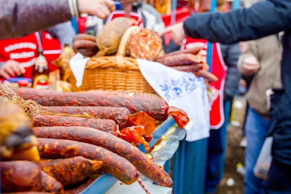 Les gens achètent de la viande fumée sur le stand, le marché de rue — Photo