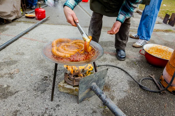 Torneando deliciosas salsichas suculentas em prato de churrasco com alça — Fotografia de Stock