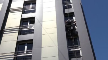 Endüstriyel dağcı yıkama, modern ofis buildingview cephe aşağıdan genç adam, iş, o bina cephe yıkama sanayi dağcı uçlarını temizleme..