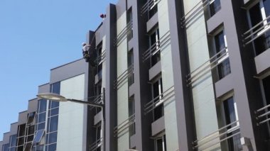 Ekip çalışması endüstriyel dağcılar, Bina cephe yıkama. Endüstriyel dağcılar vardır ayarlamak tırmanma dişli birlikte yıkanmasında, modern ofis binası Cephe Temizlik.