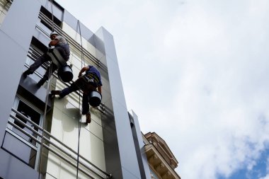Takım iş yerinde endüstriyel dağcılar onlar bina cephe yıkama vardır.