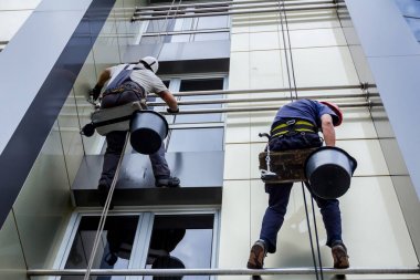 Takım iş yerinde endüstriyel dağcılar onlar bina cephe yıkama vardır.
