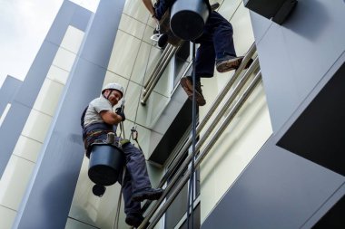 Takım iş yerinde endüstriyel dağcılar onlar bina cephe yıkama vardır.