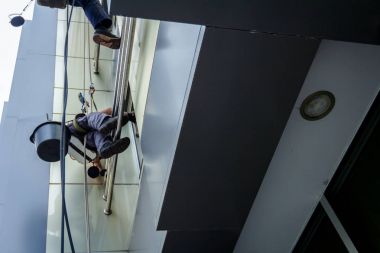 Takım iş yerinde endüstriyel dağcılar onlar bina cephe yıkama vardır.