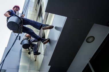 Takım iş yerinde endüstriyel dağcılar onlar bina cephe yıkama vardır.