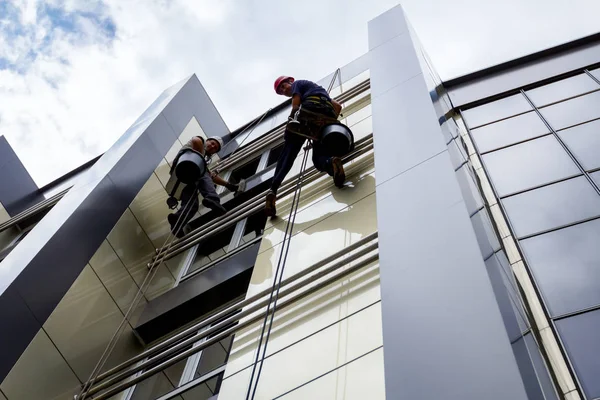 Equipo de escaladores industriales en el trabajo, están lavando la fachada del edificio . —  Fotos de Stock