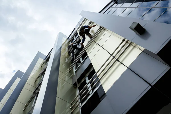 Equipo de escaladores industriales en el trabajo, están lavando la fachada del edificio . —  Fotos de Stock