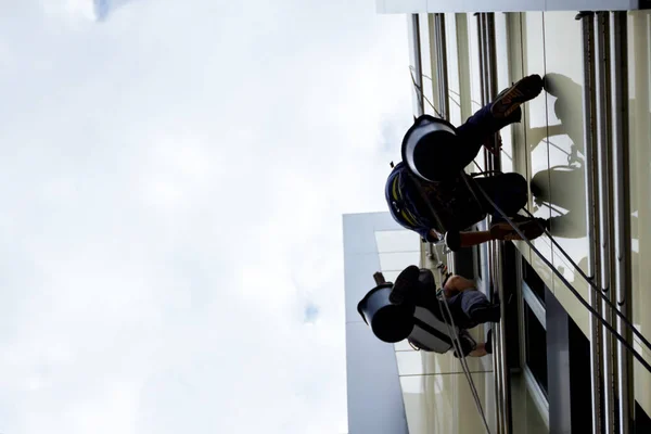 Equipo de escaladores industriales en el trabajo, están lavando la fachada del edificio . —  Fotos de Stock