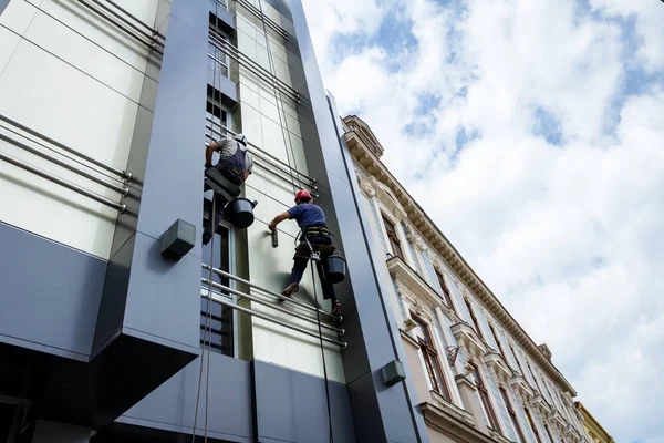 Equipo de escaladores industriales en el trabajo, están lavando la fachada del edificio . —  Fotos de Stock