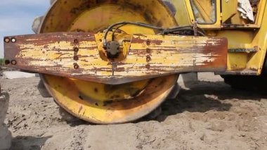 Büyük yol silindiri dikenli toprak inşaat sahasında sıkıştırma. İnşaat işçisi büyük yol silindiri dikenli sürüş ve büyük bir vakıf için toprak sıkıştırma.