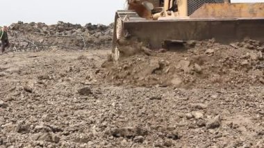 Ağır toprak taşıyıcı, buldozer makine inşaat alanında tesviye. Buldozer üzerinde iken o hareket ve site oluşturma zemin tesviye Paletli görüntülemek. 