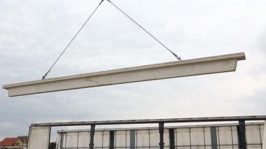 İşçi beton kiriş kamyon römork için vinç kanca bağlama. İşçi vinç kanca kamyon römork gelen boşaltma beton kiriş için hazırlanıyor.