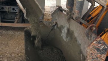Kamyon Mikser beton buldozer Kepçe yağıyor. Site oluşturma üzerinden Ekskavatör'ın ön Kepçe taşıma için taze Betonda decanting.