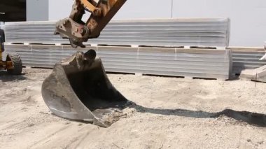 Tarak onun kova değiştirir. Tarak aracı, inşaat sahasında kova değiştirme.