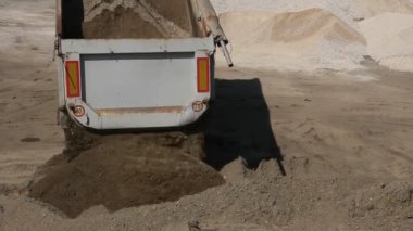 Damperli kamyon boşaltma topraktır. Damperli kamyon kum inşaat sahasında Ekskavatör aralıktaki boşaltma.