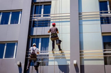 Takım iş yerinde endüstriyel dağcılar onlar bina cephe yıkama vardır