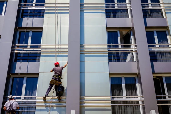 Equipo de escaladores industriales en el trabajo, están lavando la fachada del edificio — Foto de Stock