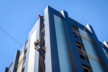Endüstriyel dağcı yıkama, modern bir ofis pencere Temizleme