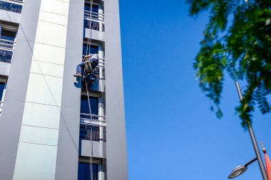 Endüstriyel dağcı yıkama, modern bir ofis pencere Temizleme