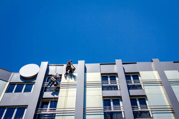 Η ομάδα της βιομηχανικής ορειβάτες στο χώρο εργασίας, αυτοί είναι το πλύσιμο πρόσοψη κτιρίου — Φωτογραφία Αρχείου