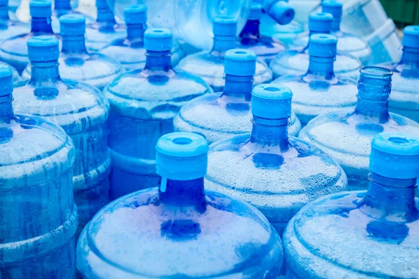 Große blaue Trinkwasserfässer, Flaschen, Gallonen, werden im Regen nass. — Stockfoto