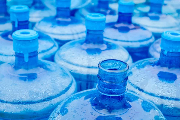 Große blaue Trinkwasserfässer, Flaschen, Gallonen, werden im Regen nass. — Stockfoto