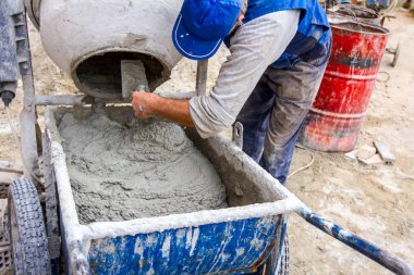 İşçi el arabasına havan topu döker. 