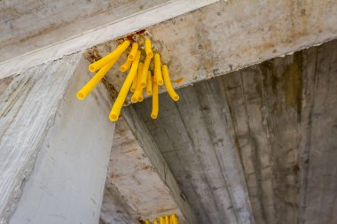 Tavandan sarı kıvrık borular çıkıyor.