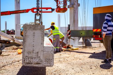 İşçi montaj ilişkisi fazla çimento sütun kesmek için değirmeni kullanıyor