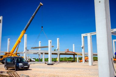 İşçiler vincin denge ve yönünü korumasına yardım ediyorlar.