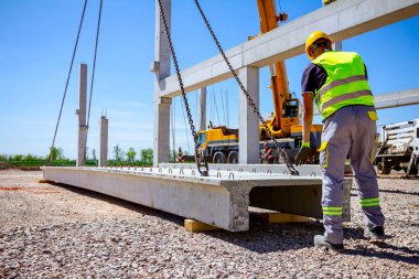 İşçiler vinçin yerden kalkmasına yardım ediyor, denge ve korku içinde.