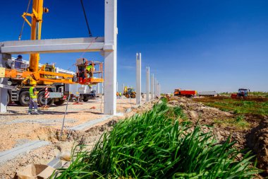 İşçiler vinçin yerden kalkmasına yardım ediyor, denge ve korku içinde.