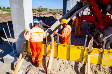 Uzun kalıpta güçlendirilmiş beton dökülüyor