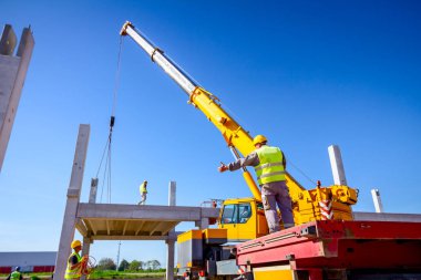 Patron büyük montaj için beton kirişini denetliyor, kontrol ediyor.