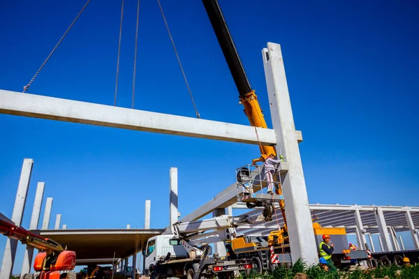 Mobiele kraan is het dragen van beton joist te monteren enorme hal — Stockfoto