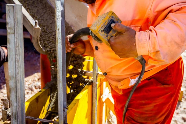 Travailleur utilise vibratoire électrique pour le béton compact en bois — Photo