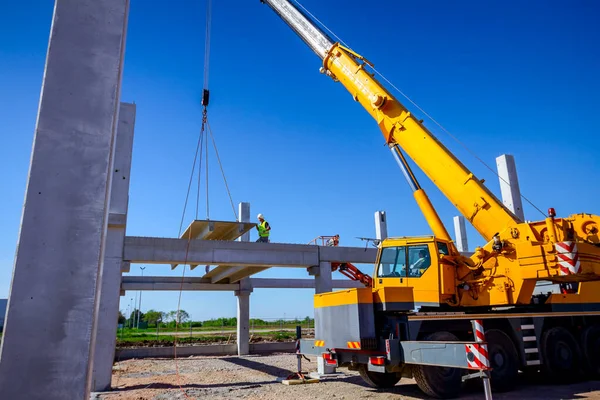 Arbejdstagere hjælper kranen med at holde balancen og retningen for konkur rencen - Stock-foto